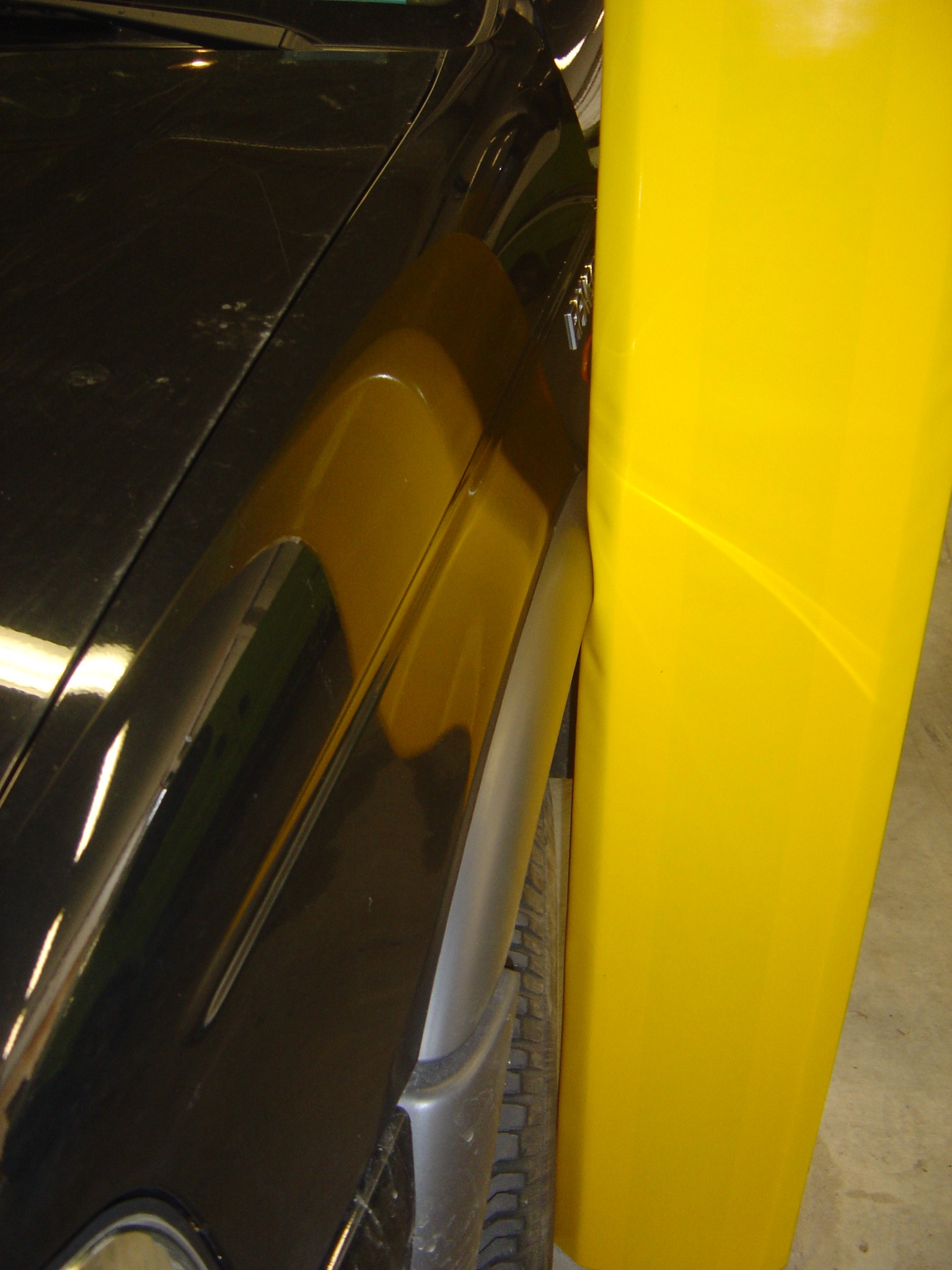 A close-up of a car parked roughly against a column with a Cingo Parking Wrap installed on it, protecting both the car and the column from sustaining any damage