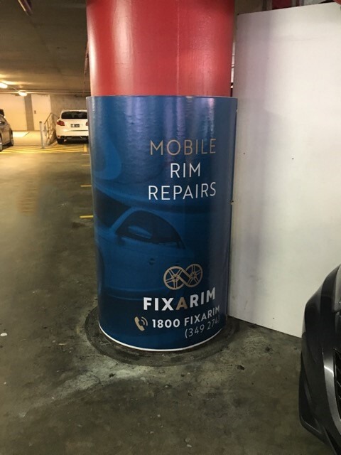 A column in a parking garage with a Cingo Protective Wrap installed advertising a mobile car repair service