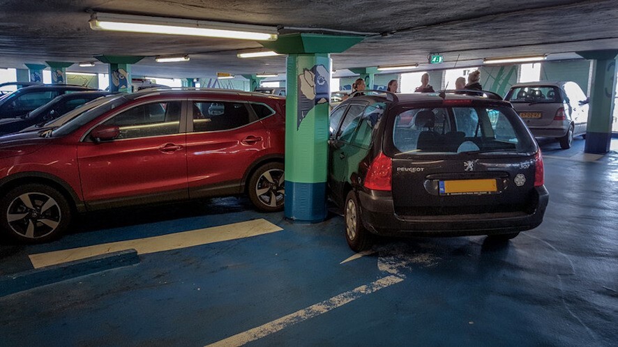 Two cars parked against a column protected by a Cingo Parking Wrap to prevent the column or either var from sustaining damage