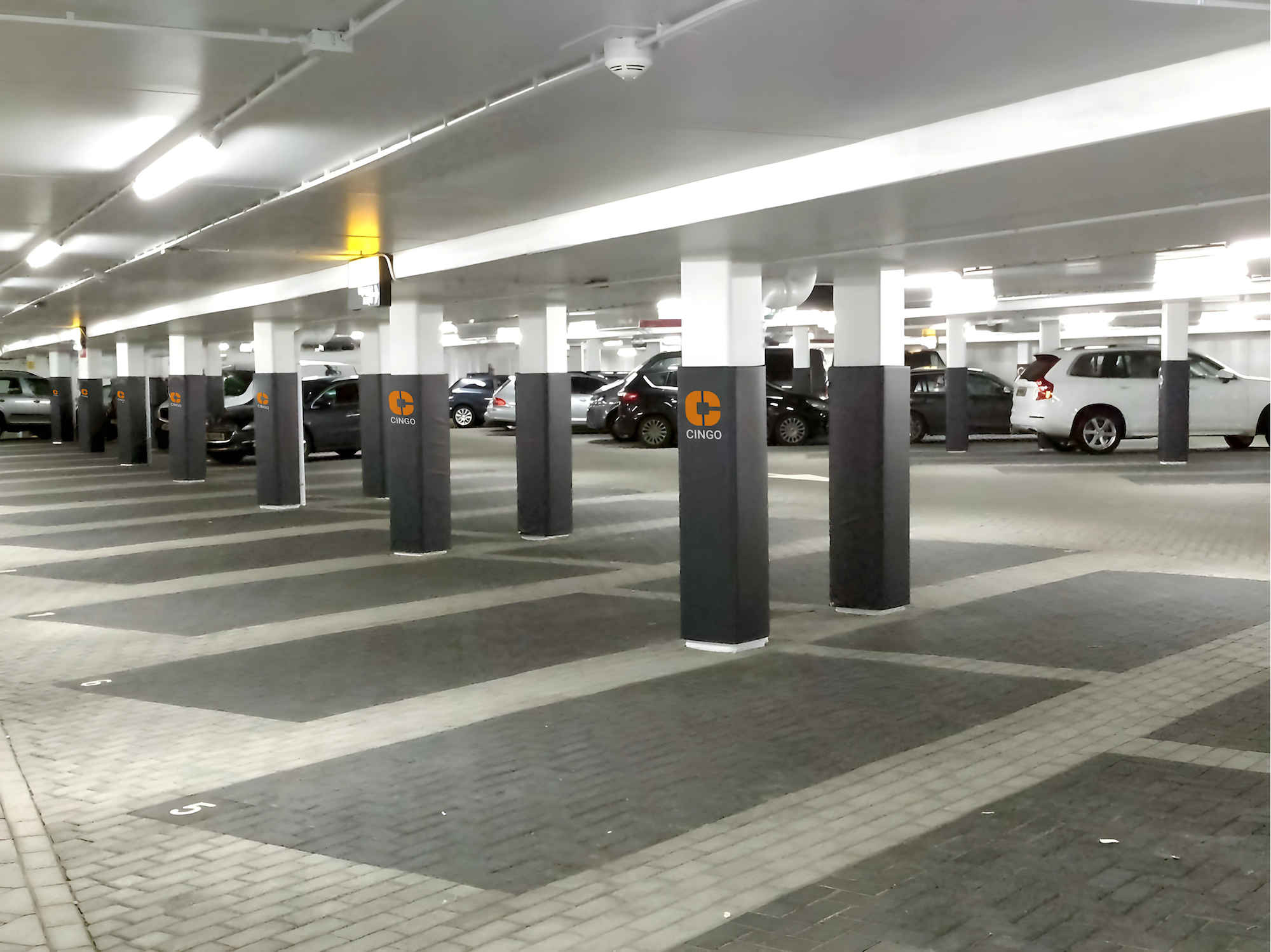 Columns in a parking garage with a Cingo Protective Wrap installed printed with the Cingo logo on the Wrap