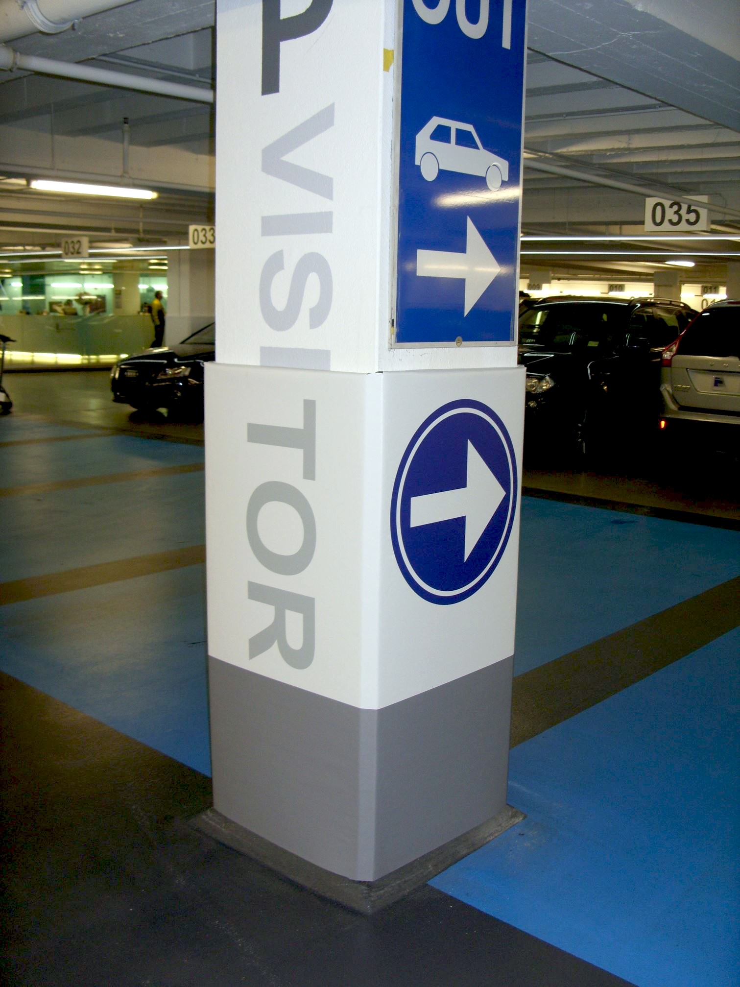 A column in a parking garage with a Cingo Protective Wrap installed that is printed to show visitors where they can and can't park