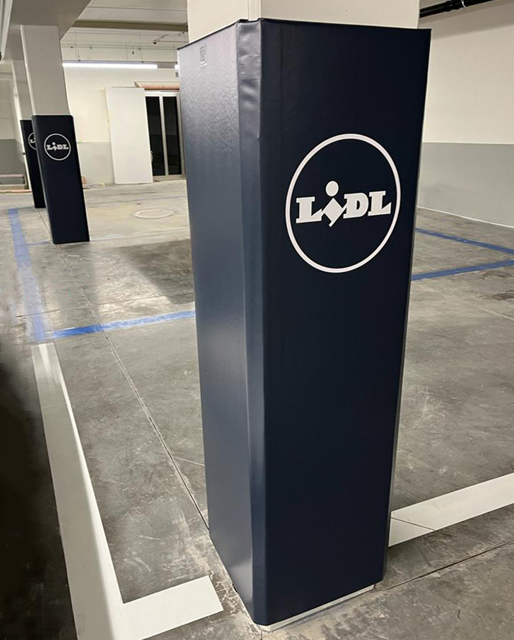 Square columns in a parking garage with Cingo Protective Wraps branded with the Lidl logo installed