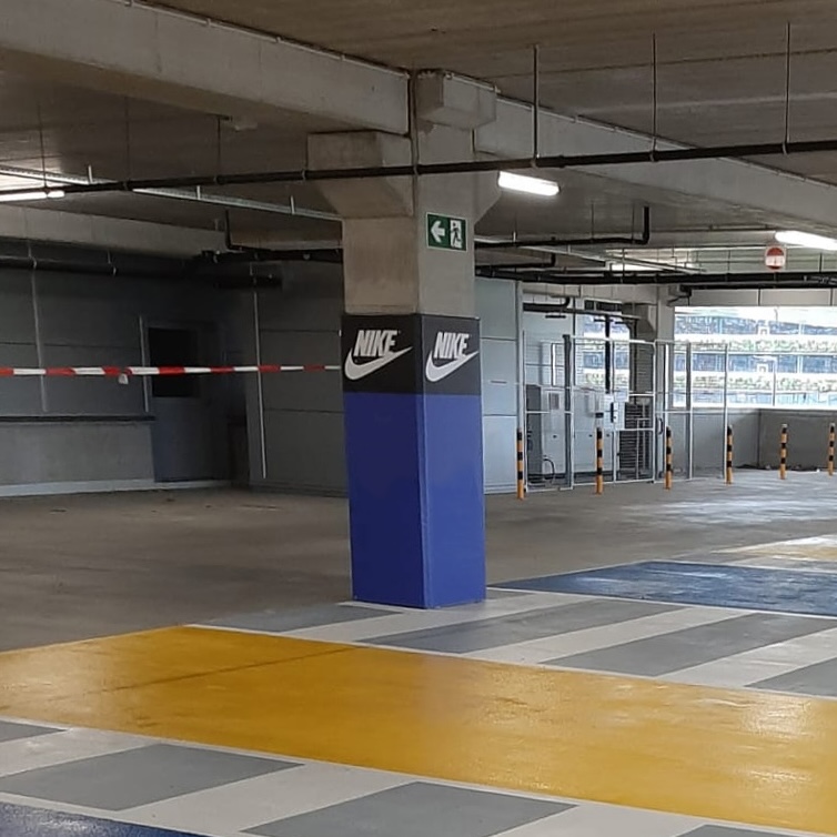 A column in a parking garage with a Cingo Protective Wrap installed with Nike branding