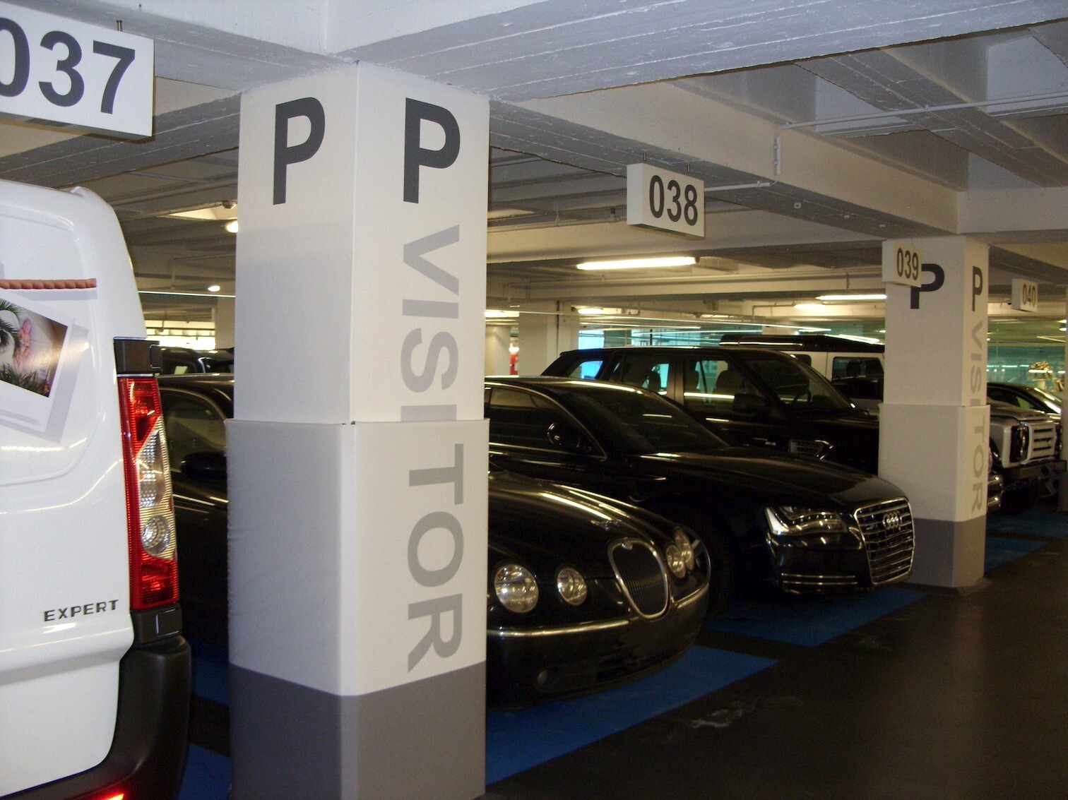 Columns in a parking lot with Cingo Protective Wraps installed that are designate certain parking spots for different uses